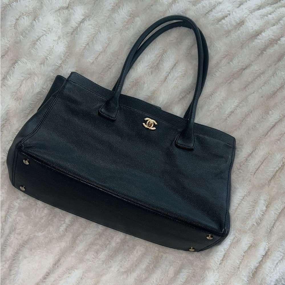 Black vintage Chanel leather bag with straps.